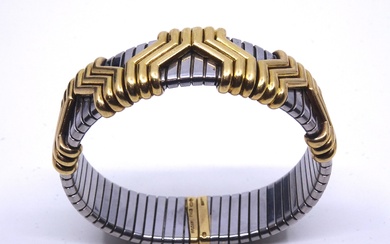 BULGARI. Bracelet demi rigide en acier Tubogas appliqué de motifs godronnées en or jaune (750...
