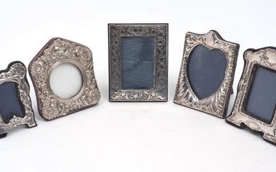 Four small silver mounted photo frames, including one with tulip decoration to border, London, 1987, Paul Vernon Fitchie, 9.2 x 12.1cm, together with a silver plated example with repousse floral scroll border (5)