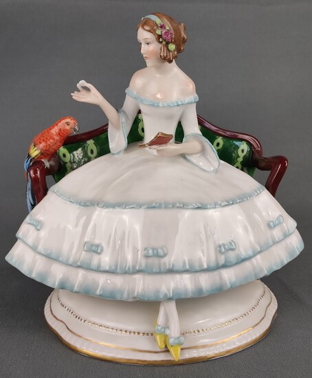 Porcelain figure, young girl on green bench with red parrot, dressed in white dress with light blue