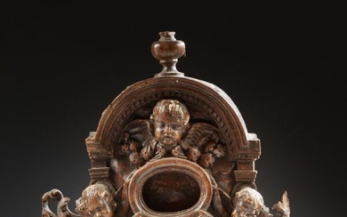 Porte-reliquaire en noyer sculpté en fort relief avec partie supérieure cintrée représentant deux angelots assis...
