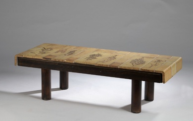 Roger CAPRON (1922-2006). Table basse rectangulaire en bois verni, plateau débordant doublé à vingt-quatre carreaux...