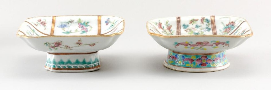 TWO NEAR-MATCHING CHINESE FAMILLE ROSE PORCELAIN FOOTED DISHES Square, with interior decoration of flowers and insects on a bisected...