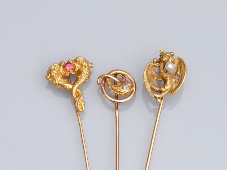 Three tie pins in 750°/00 (18K) yellow gold, decorated with chimeras and snake; set with small pearls, antique cut diamond, garnet. Late 19th century. 6.3 g. Hallmarks eagle's head and horse