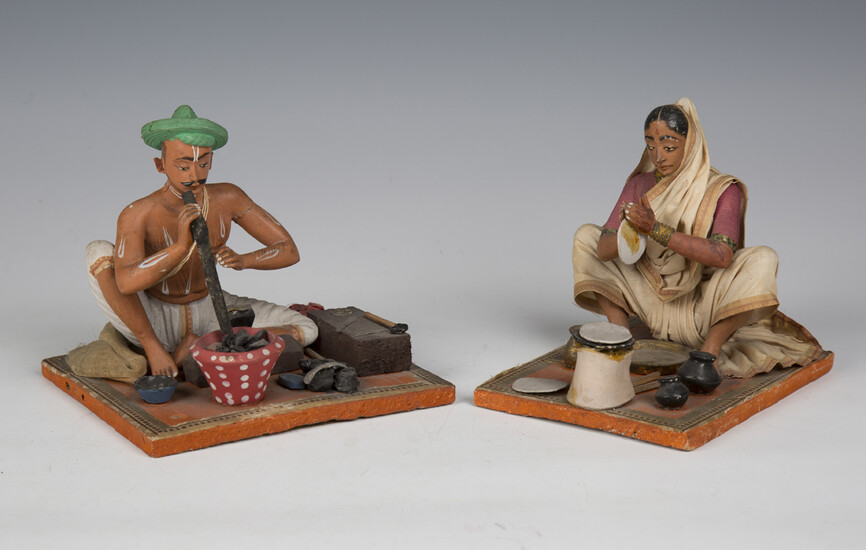Two 20th century Indian clay figures of a seated man and woman, height 13cm, together with a painted