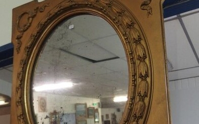 Un miroir ovale, cadre en bois mouluré et...