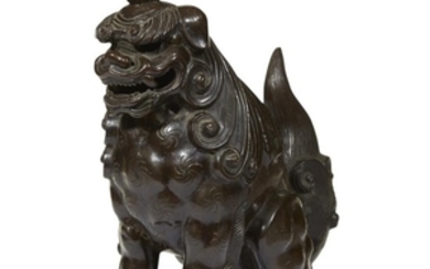 A Japanese patinated and inscribed bronze seated guardian lion...