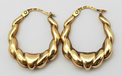 A 9 K yellow gold pair of hoop earrings...