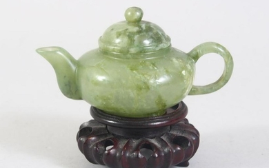 A CHINESE MOTTLED GREEN JADE TEA POT ON PIERCED AND