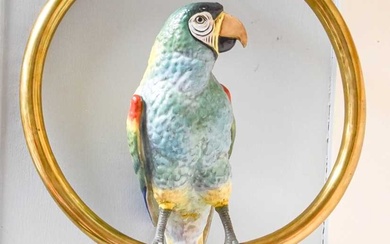 A Continental Porcelain Parrot, on hanging brass ring perch Th...