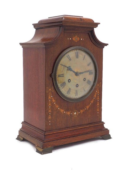 A German inlaid mahogany cased eight-day chiming mantel clock by Gustav Becker, early 20th century, decorated with a harebell swag beneath a brass dial set with Roman numerals, on brass bracket feet, 41cm Please note Roseberys do not guarantee the...