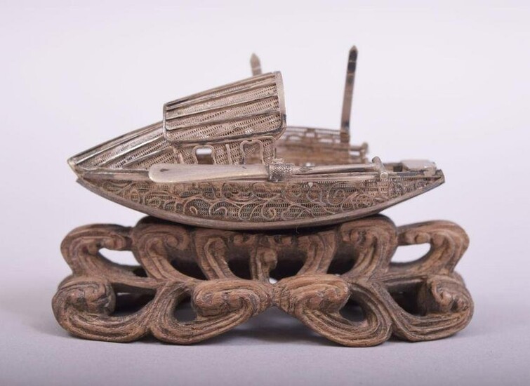 A SMALL CHINESE FILIGREE MODEL OF A JUNK, on a wooden