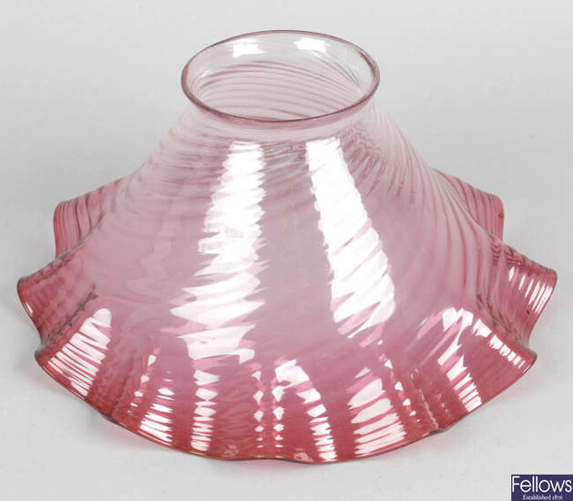 A cranberry glass oil lamp shade of frilled form, together with two wall hanging mirrors, etc.