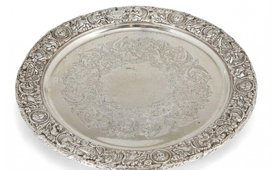 A decorative silver serving plate, London, c.1920, Mappin & Webb, the pierced rim richly decorated with lions, urns and masks to a flat base engraved with foliate and eagle design wreath, the plate raised on three bracket feet, 27.5cm dia., approx...