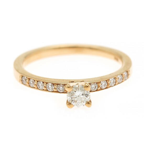 A diamond ring set with a diamond weighing app. 0.21 ct. flanked by ten diamonds weighing a total of app. 0.13 ct., mounted in 18k gold. Size 53.