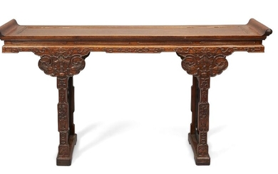 A fine Chinese Huanghuali and Zitan Altar Table, late 19th century, the top constructed with a single board floating panel and everted flanges, the waisted apron carved with key fret and bats, the trestle end supports inset with Zitan frames...