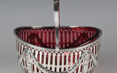 A late Victorian silver oval bonbon basket with reeded swing handle, the pierced sides embossed with