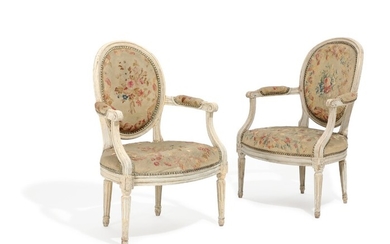 A pair of 18th century white painted Louis XVI armchairs with curved armrests and fluted legs. (2)