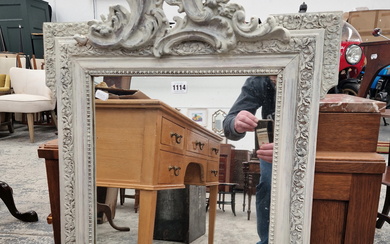 AN ANTIQUE WALL MIRROR WITH CARVED WOOD AND GESSO FRAME.