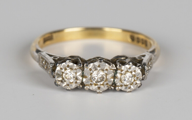 An 18ct gold ring, mounted with a row of three circular cut diamonds between diamond two stone shoul
