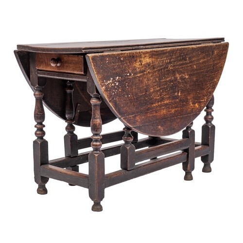 An 18th Century oak oval gateleg dining table:, with a hinge...