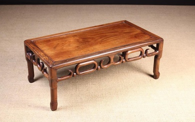 An Antique Chinese Rosewood Low 'Kang' Table. The rectangular top in a moulded frame above a pierced