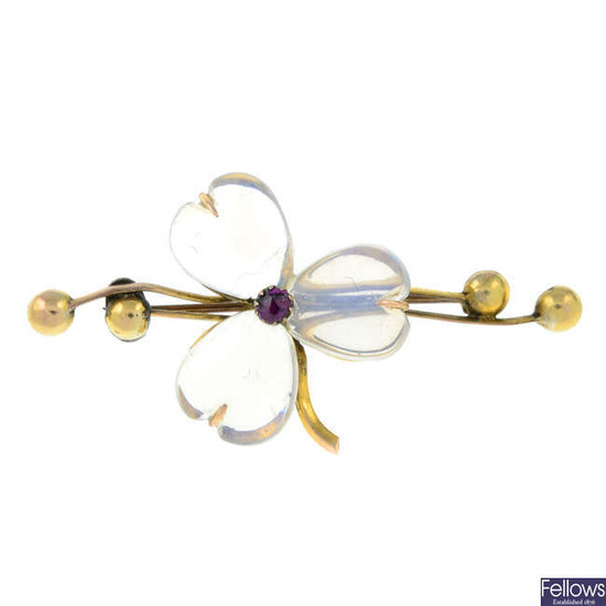 An early 20th century gold moonstone and ruby floral brooch.