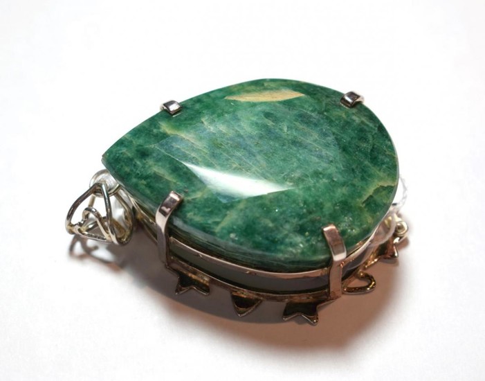 An emerald pendant, the pear cut emerald in a white...