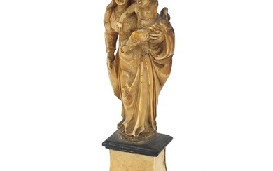 Antique ivory carving of Madonna and child raised on an ebon...