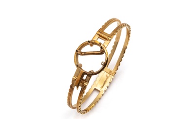 Bracelet jonc rigide ouvrant à charnières en or 750 millièmes, à décor ajouré et festonné....