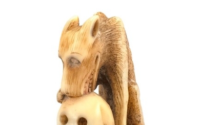 JAPANESE BONE NETSUKE In the form of a wolf with a decaying human skull. Height 1.6".
