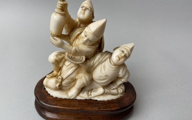 JAPON, c. 1930. Okimono en ivoire sculpté représentant trois hommes buvant, signé à la base....