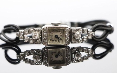 Montre de dame en platine et diamants de taille brillant, le bracelet en tissu noir tressé.