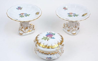 Three pieces of Herend Queen Victoria VA porcelain, including a pair of tazza with dolphin form tripod bases, 10cm high, and a lidded box, 10cm diameter (3)