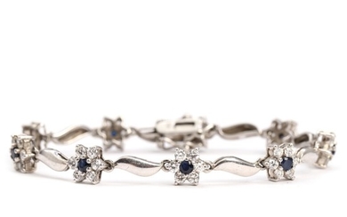 A sapphire bracelet set with nine round-cut sapphires and numerous clear gemstones, mounted in sterling silver. L. 19 cm.