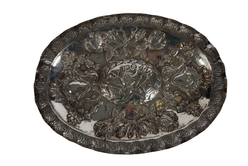 15 Plat ovale à ombilic en argent à décor au repoussé de trophée, d’armes, fleur