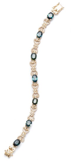 A 18CT GOLD SAPPHIRE AND DIAMOND BRACELET; featuring 7 blue/green oval cut sapphire set links totalling approx. 7.00cts, between 6 f...