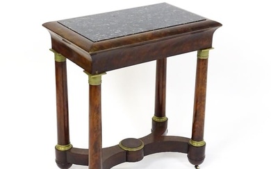 A 19thC French Empire mahogany table with a marble top above four turned legs with gilt caps, the