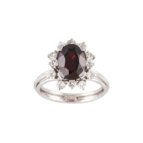 A GARNET AND DIAMOND CLUSTER RING, the oval garnet to a bril...