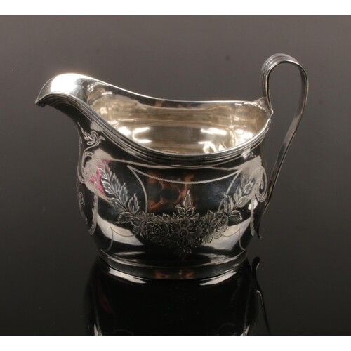 A George III silver cream jug. With reeded strap handle and ...
