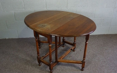 A chestnut gateleg table, early 19th century, with plain oval drop leaf top on turned supports with