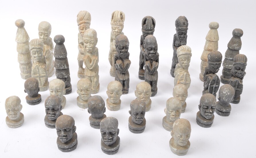 A collection of 20th century carved composite stone tribal figures in a variety of sizes and positions, each wearing traditional dress. Measures approx 17cm tall.