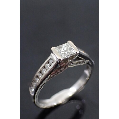 A diamond solitaire ring set with diamond shoulders in 18k g...