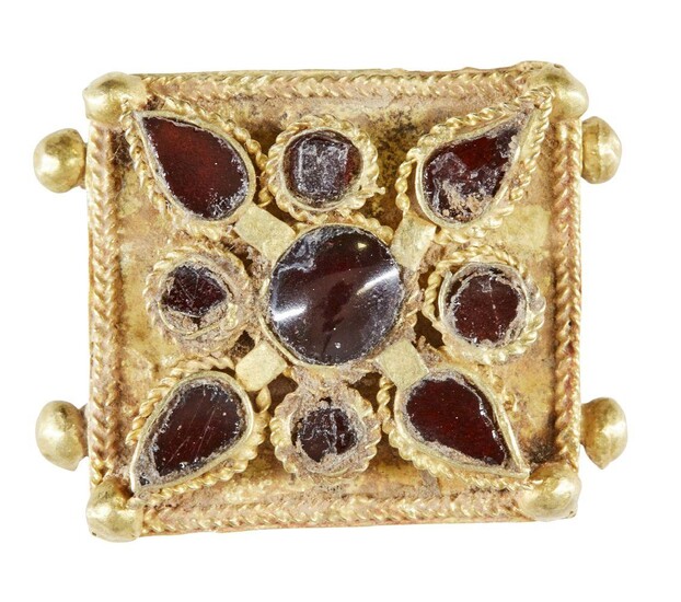 A garnet set gold element, Iran, 12th-13th century, of square form, the central stone with a teardrop shaped stone at each corner, and round stones to interstices, all in raised settings, border of gold braid, with two gold ball elements to each...