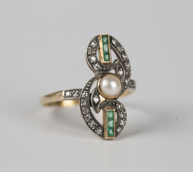 A gold and silver set, diamond, emerald and half-pearl ring in a scroll pierced openwork design, col