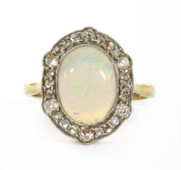 A gold opal and diamond ring, an oval cabochon opal,...