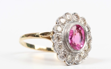 A gold, pink tourmaline and diamond oval cluster ring, collet set with the oval cut pink tourmaline