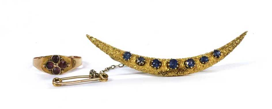 A gold sapphire set crescent brooch