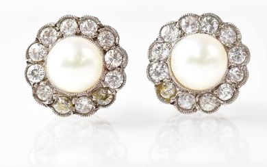 A pair of stud earrings set with pearls in a...
