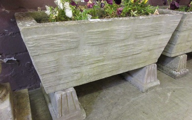 A rectangular weathered stoneware planter on blocks with flowersCondition Report...