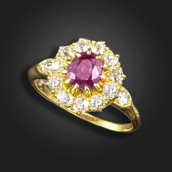 A ruby and diamond cluster ring, the oval-shaped ruby set...